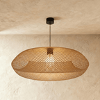 Clérachic woven rattan pendant light with an open-weave oval shade, suspended from a round black ceiling canopy.