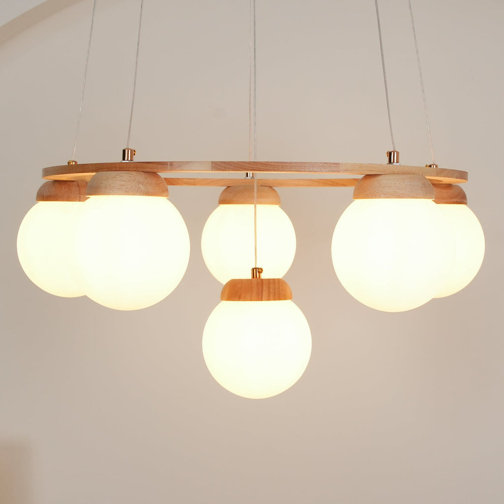 Side-on view of the warm-lit globes beneath the wood ring of this Clérachic chandelier, one globe hanging lower at the centre.