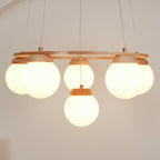 Side-on view of the warm-lit globes beneath the wood ring of this Clérachic chandelier, one globe hanging lower at the centre.