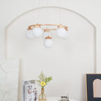 A pale arched wall, flowers and a framed print surround this Clérachic wood-ring chandelier, seen from below with its globes unlit.