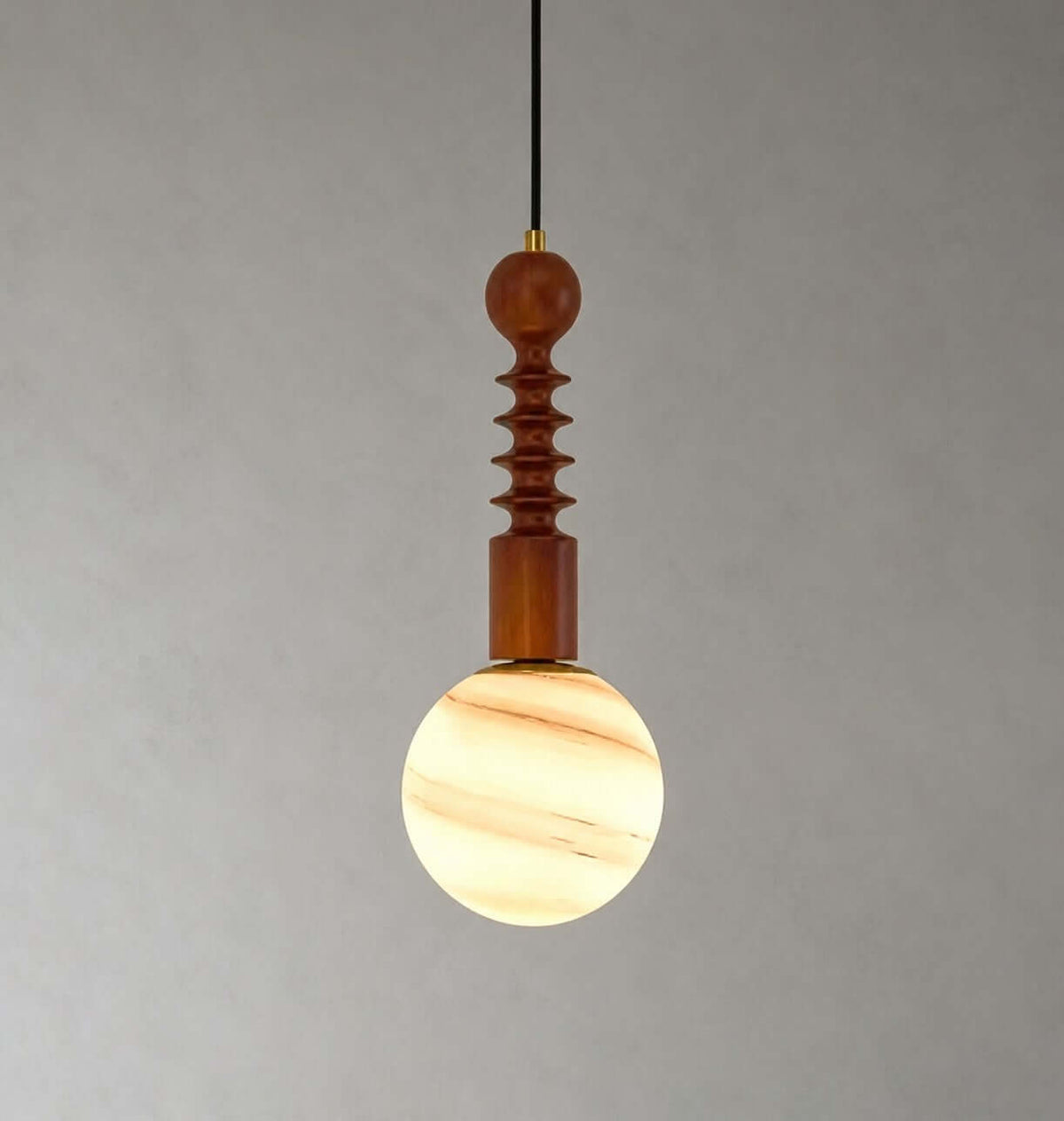 The ribbed wood stem and a cream-and-amber banded globe of this Clérachic pendant, lit against a plain grey wall.