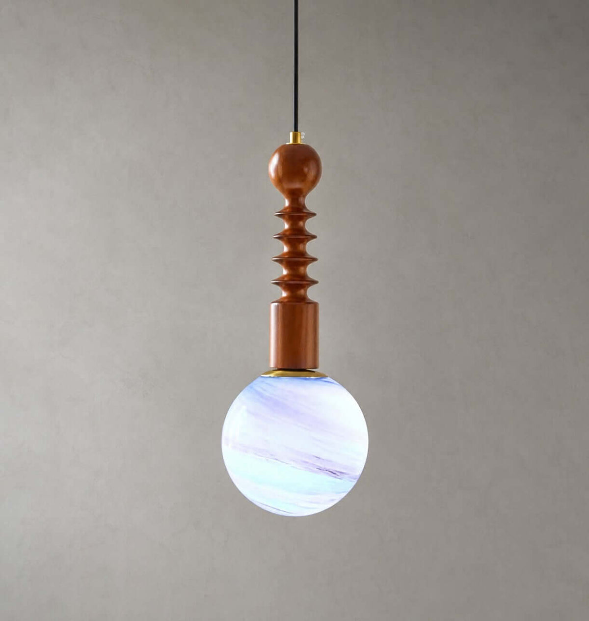 Blue and violet swirls through the glass globe of this Clérachic pendant, which has a ribbed wooden stem, on grey.