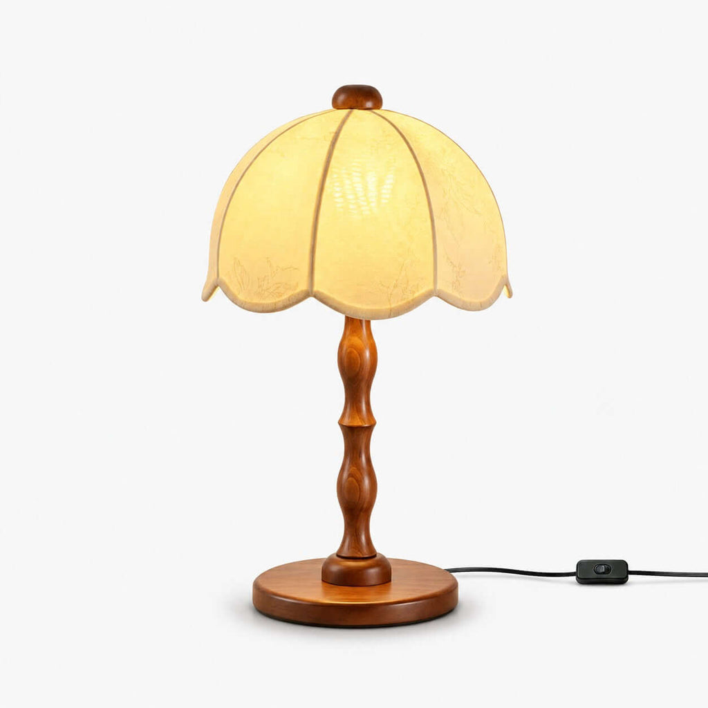 Clérachic table lamp with a scalloped cream shade and a turned walnut stem and base, with an inline switch on the cord, on white.