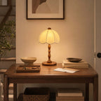 A Clérachic table lamp with a walnut base on a wooden console table, beside a bowl, a tray and a letter.