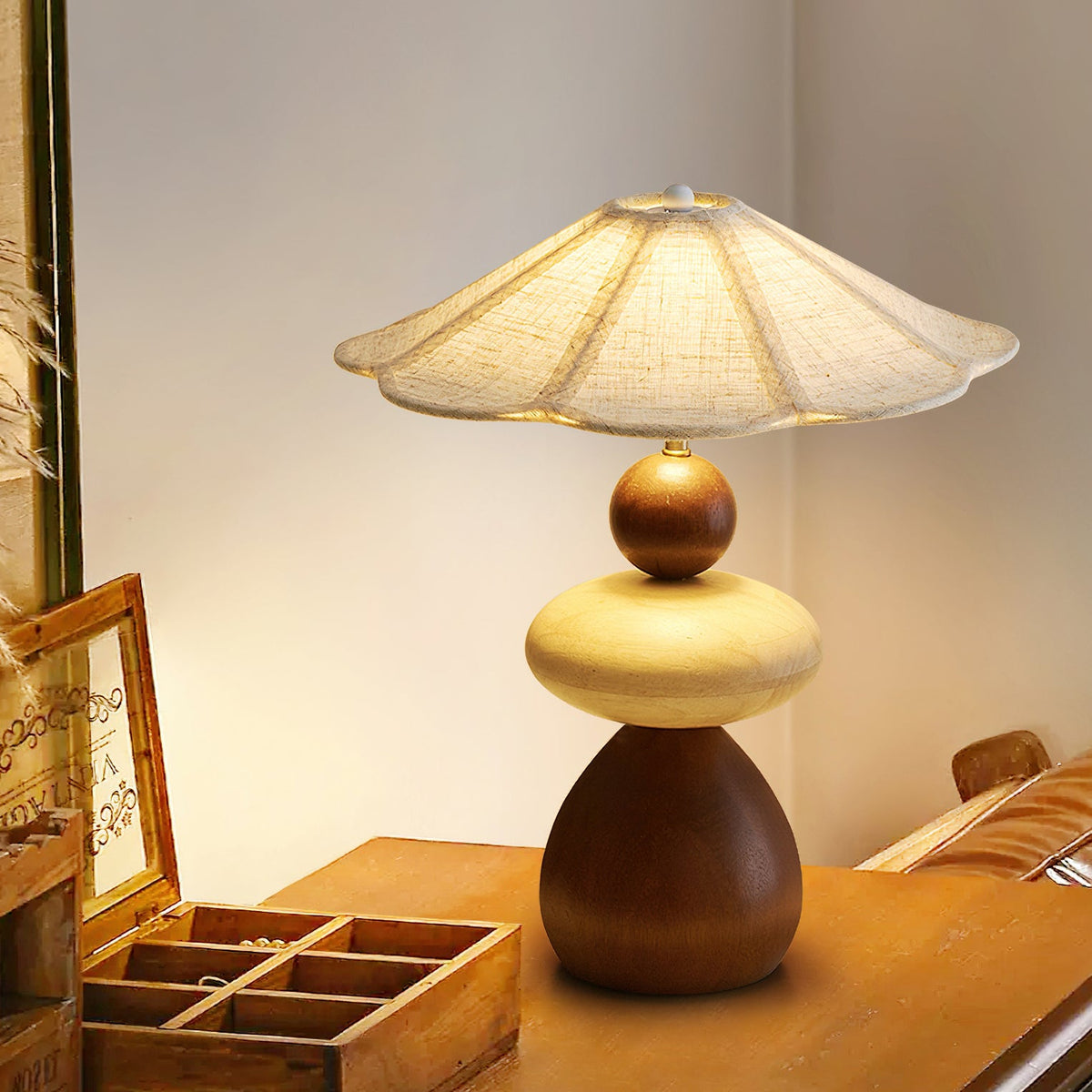 Seen from the side, this Clérachic table lamp stands on a wooden table beside an open wooden tray box and a small picture frame.