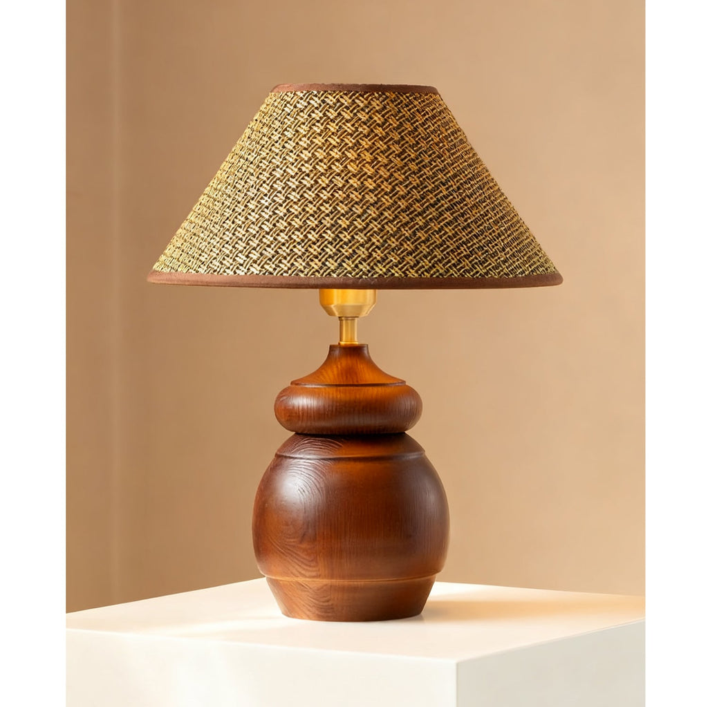 Broad straw weave shade on a round, grained wood base: a Clérachic table lamp against a warm tan wall.