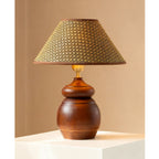Broad straw weave shade on a round, grained wood base: a Clérachic table lamp against a warm tan wall.