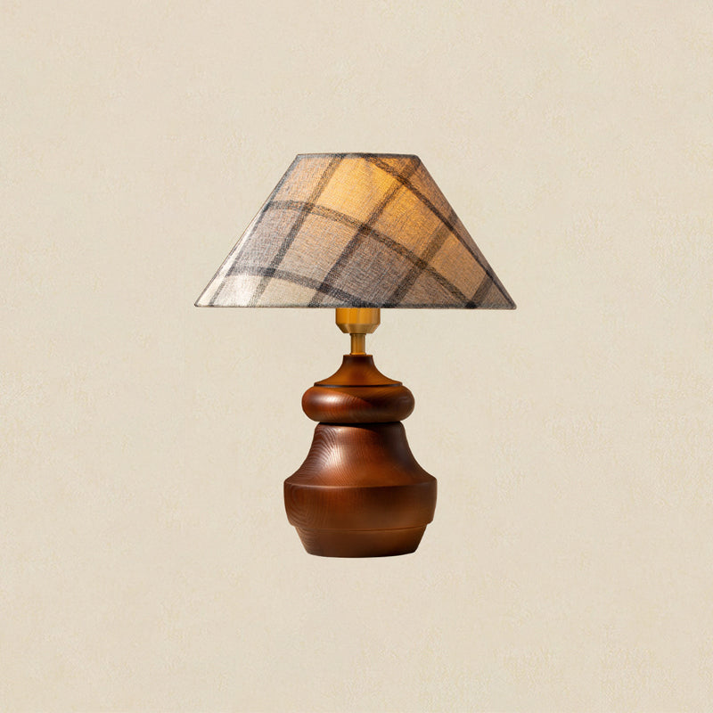 A Clérachic plaid-shade table lamp with a wood base that curves out at the foot, on a soft beige backdrop.