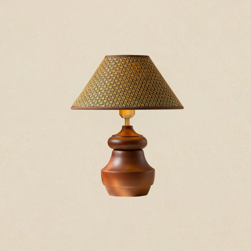 Wood base with a wide shoulder under a straw weave shade, this Clérachic table lamp on a soft beige backdrop.