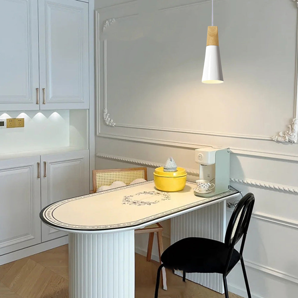 A slim white Clérachic cone pendant glows over a curved breakfast bar in a white panelled kitchen nook.