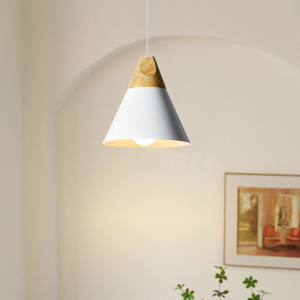 Close-up of the white Clérachic cone pendant lit beneath an archway, showing its wood cap and glowing bulb.