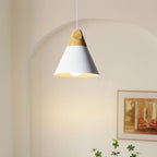 Close-up of the white Clérachic cone pendant lit beneath an archway, showing its wood cap and glowing bulb.