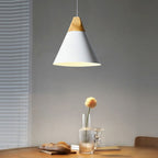 This wide white Clérachic cone pendant is shown head-on, lit above a wooden table beside a slatted blind.