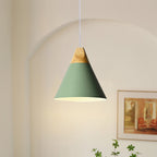 Close-up of the wide green Clérachic cone pendant lit in an arched alcove, its bulb glow spilling onto the wall.