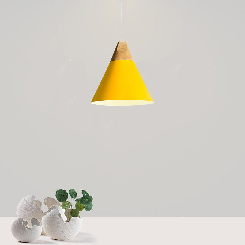 This wide yellow Clérachic cone pendant, wood cap included, is photographed against a plain grey studio wall.