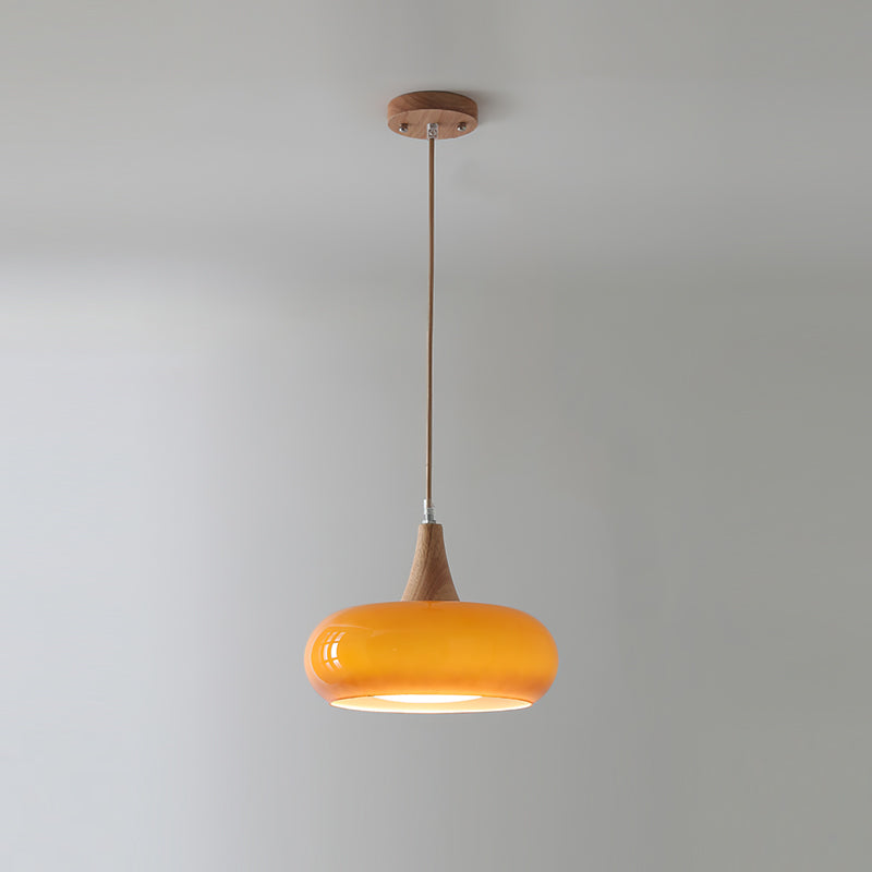 Clérachic Wood-Top Glass Pendant Light in amber glass, a single lit head hanging from its round wood ceiling canopy.