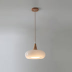 The Clérachic Wood-Top Glass Pendant Light in opal white glass, one head glowing softly beneath its turned wood cap.