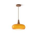 Clérachic Wood-Top Glass Pendant Light shown on white, the amber shade capped by a turned wood cone above a braided cord.
