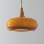 Close-up of the amber Clérachic Wood-Top Glass Pendant Light, its open rim revealing the recessed white diffuser disc inside.