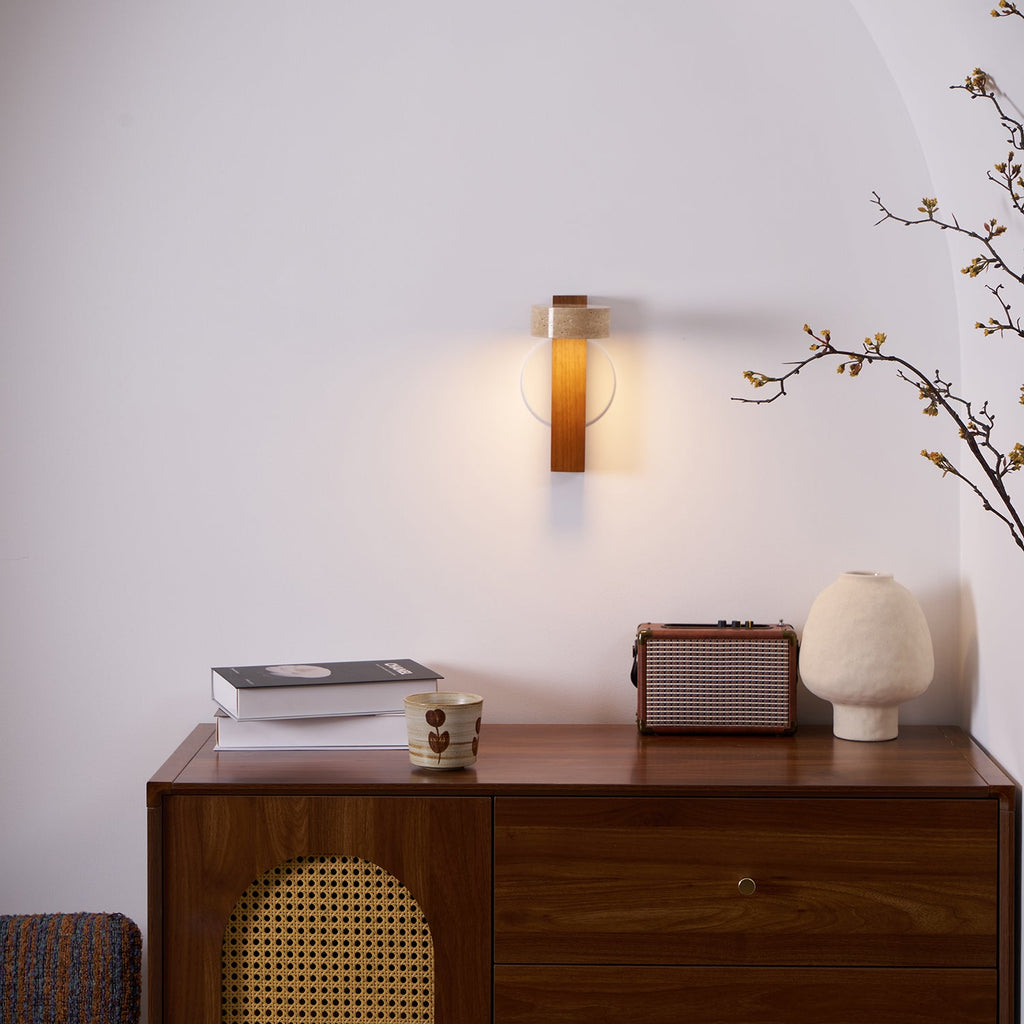 A Clérachic wall light glows in an arched alcove above a walnut sideboard with a cane front, a retro radio and a cream vase.