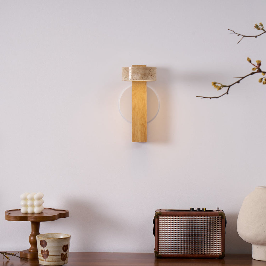 This Clérachic wall light in pale wood with the head turned inward hangs above a wooden shelf with a cake stand, a radio and a cup.
