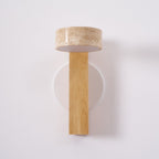A Clérachic wall light in pale wood switched off, showing the white underside of its travertine head and the round backplate.