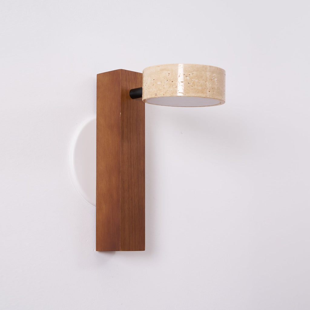 This Clérachic wall light with a dark walnut-coloured bar has its travertine head turned sideways on a black pivot.