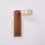 This Clérachic wall light with a dark walnut-coloured bar has its travertine head turned sideways on a black pivot.