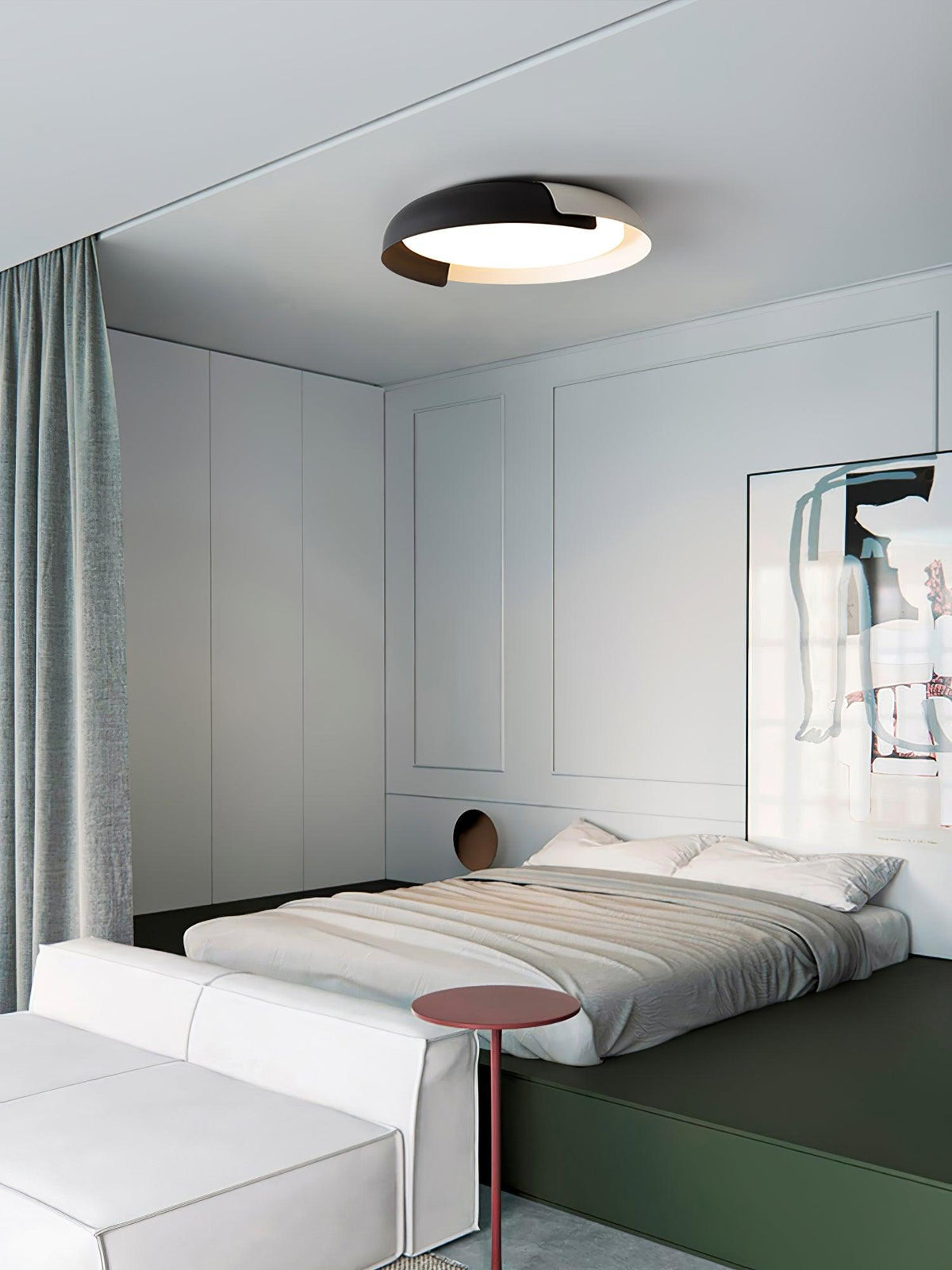 A black and dark wood Clérachic ceiling light above a low bed with grey bedding and a red-brown side table, with a green base.