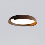 A black and dark wood Clérachic ceiling light with a grey-brown inner rim, lit, on a pale grey backdrop.