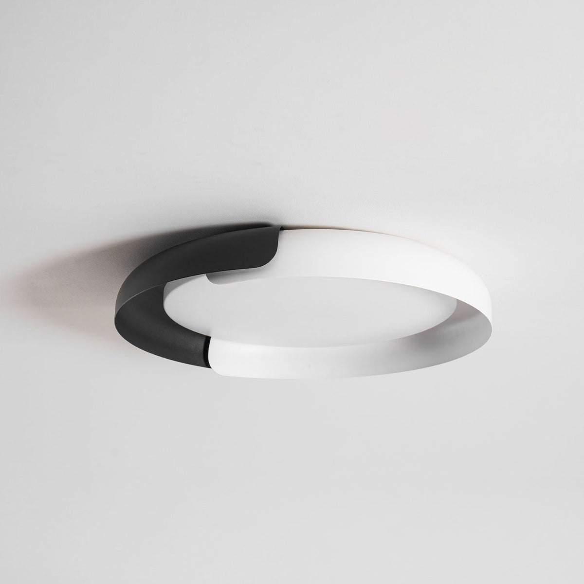 A white and black Clérachic ceiling light with a frosted diffuser, seen from below against a pale grey ceiling.