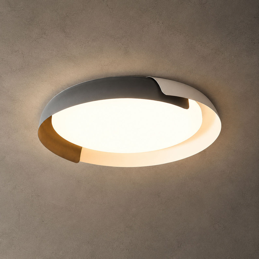 A grey and wood Clérachic ceiling light lit with a warm glow against a textured grey-brown ceiling.
