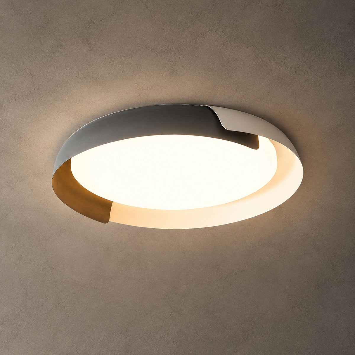 A grey and wood Clérachic ceiling light lit with a warm glow against a textured grey-brown ceiling.