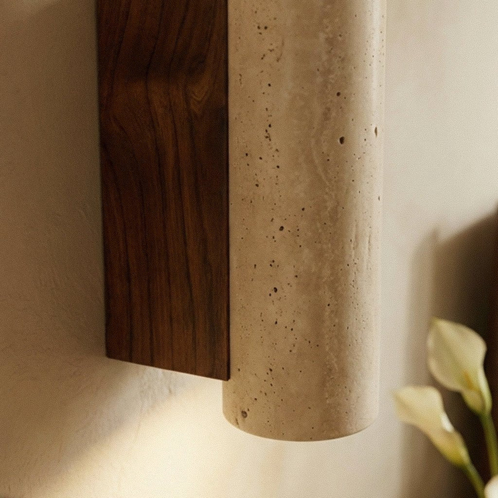 A macro detail of the Clérachic wall lamp's round stone shade meeting its dark walnut base.