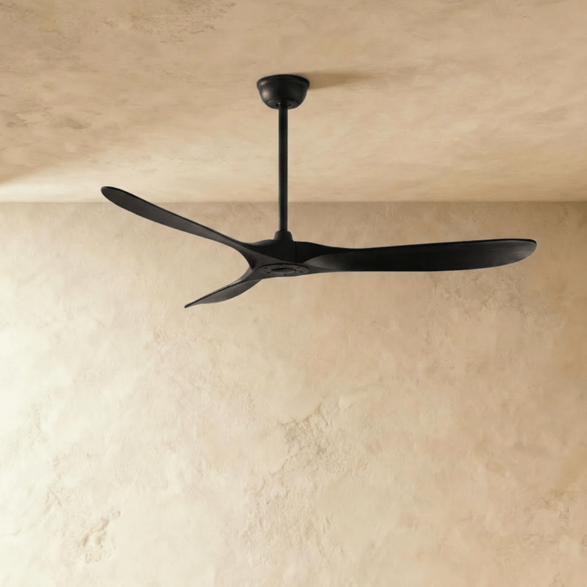 Clérachic all-black three-blade ceiling fan on a slim downrod, shown against a soft limewash backdrop in the studio