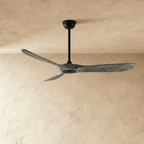 Clérachic ceiling fan with grey wood-grain blades and a black body, hung on a downrod in the studio