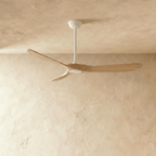Clérachic ceiling fan in white and natural wood, with three curved blades on a white downrod, photographed in the studio