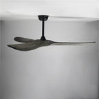 Clérachic ceiling fan seen from the side, showing grey wood blades tilted on a black downrod and canopy in a plain room