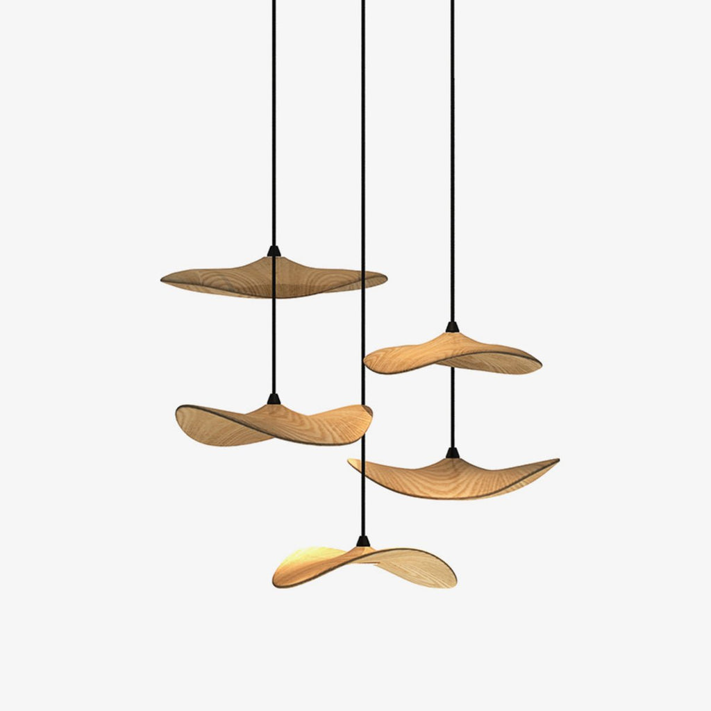 Five wooden leaf-shaped pendants from Clérachic hung at different heights on slim black cables, on a plain white background.