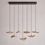 Seven Clérachic leaf pendants hanging from a long black rectangular canopy, on a plain pale background.