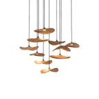 Twelve Clérachic wooden leaf pendants in a loose cluster on slim black cables, shown on a plain white background.