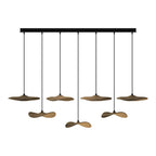 Seven Clérachic leaf pendants in walnut colour on a long black bar canopy, hanging at alternating levels.