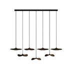 Seven Clérachic leaf pendants in dark walnut colour on a long black bar canopy, at alternating heights.