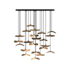 Cluster of light wood Clérachic leaf pendants on a long black canopy, hung in many layers, on a white background.