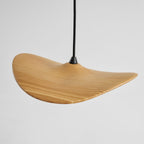 Close view of the striped ash grain on one curved Clérachic wooden leaf pendant and its black cord.