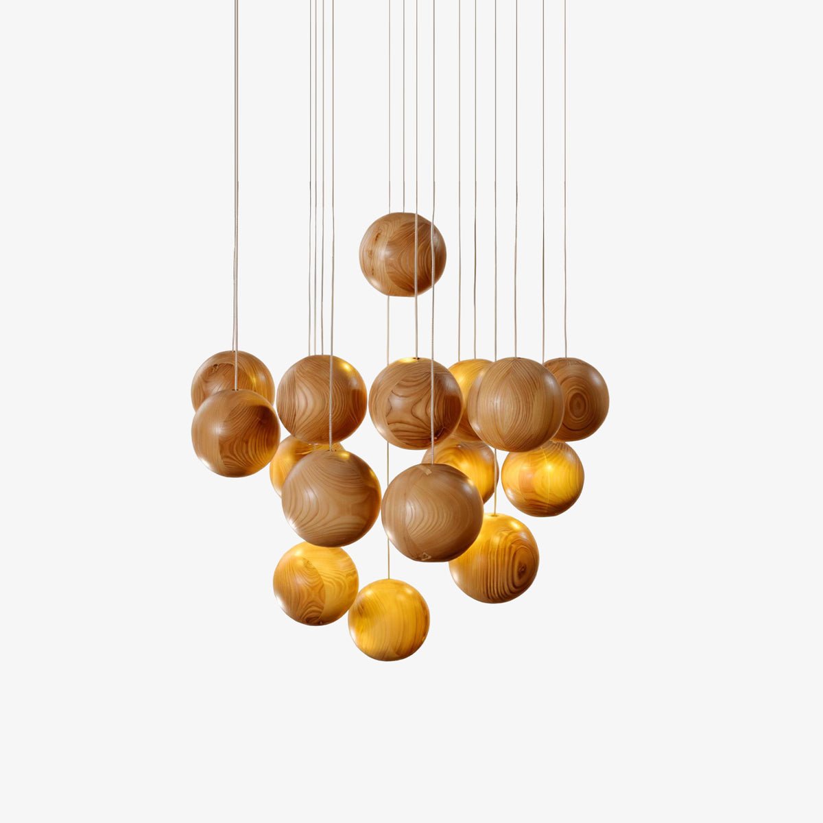 This Clérachic pendant light on a plain white backdrop, a cluster of natural wood spheres hung at different heights on thin cords.