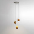 A three-sphere Clérachic wood pendant on a small round ceiling plate, one sphere glowing warm below two unlit spheres.