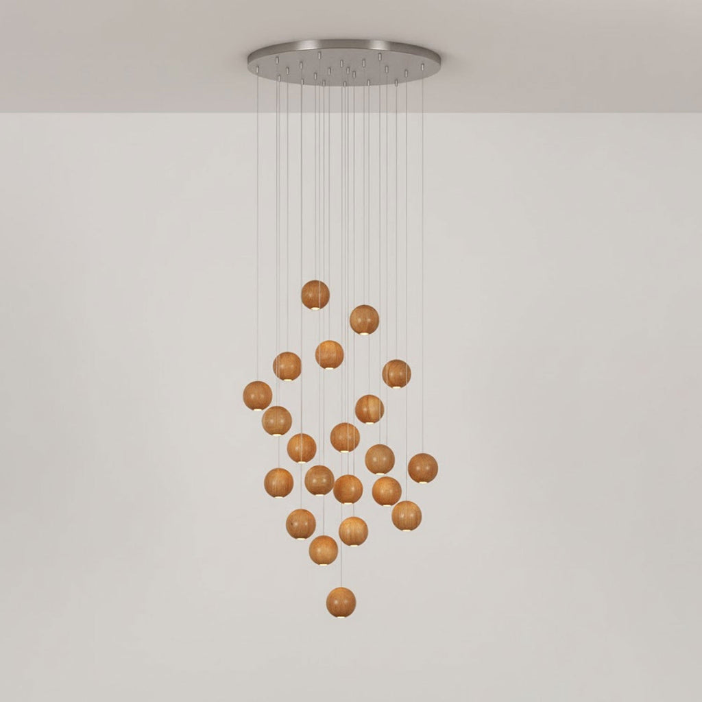 A Clérachic wood pendant on a round ceiling plate, with the spheres in a loose diamond shape on a pale wall.