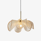 Woven abaca petals fanning out from a slim brass stem on this Clérachic pendant, lit on a plain pale backdrop.
