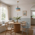 This Clérachic pendant in blue and white hangs in a bright breakfast corner with a round oak table and a window seat.